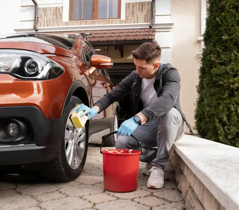 Lavage auto à domicile Tessy-Bocage : professionnel intervenant sur un véhicule